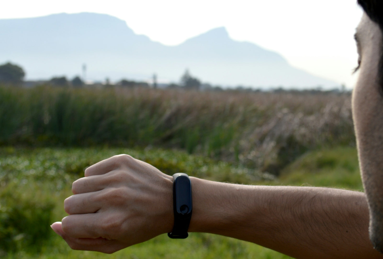 Hombre revisando su pulsera de actividad física al aire libre